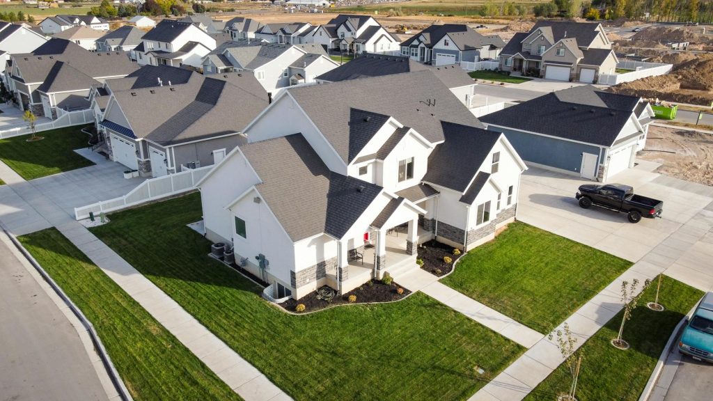 Aerial shot of a residential area in Spanish Fork, Utah showcasing modern homes and manicured lawns.