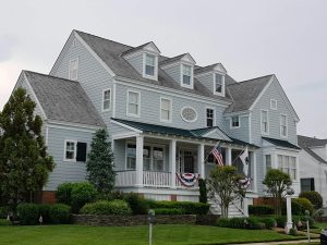 Elegant colonial-style house in Cape May, NJ with manicured lawn and American flags.